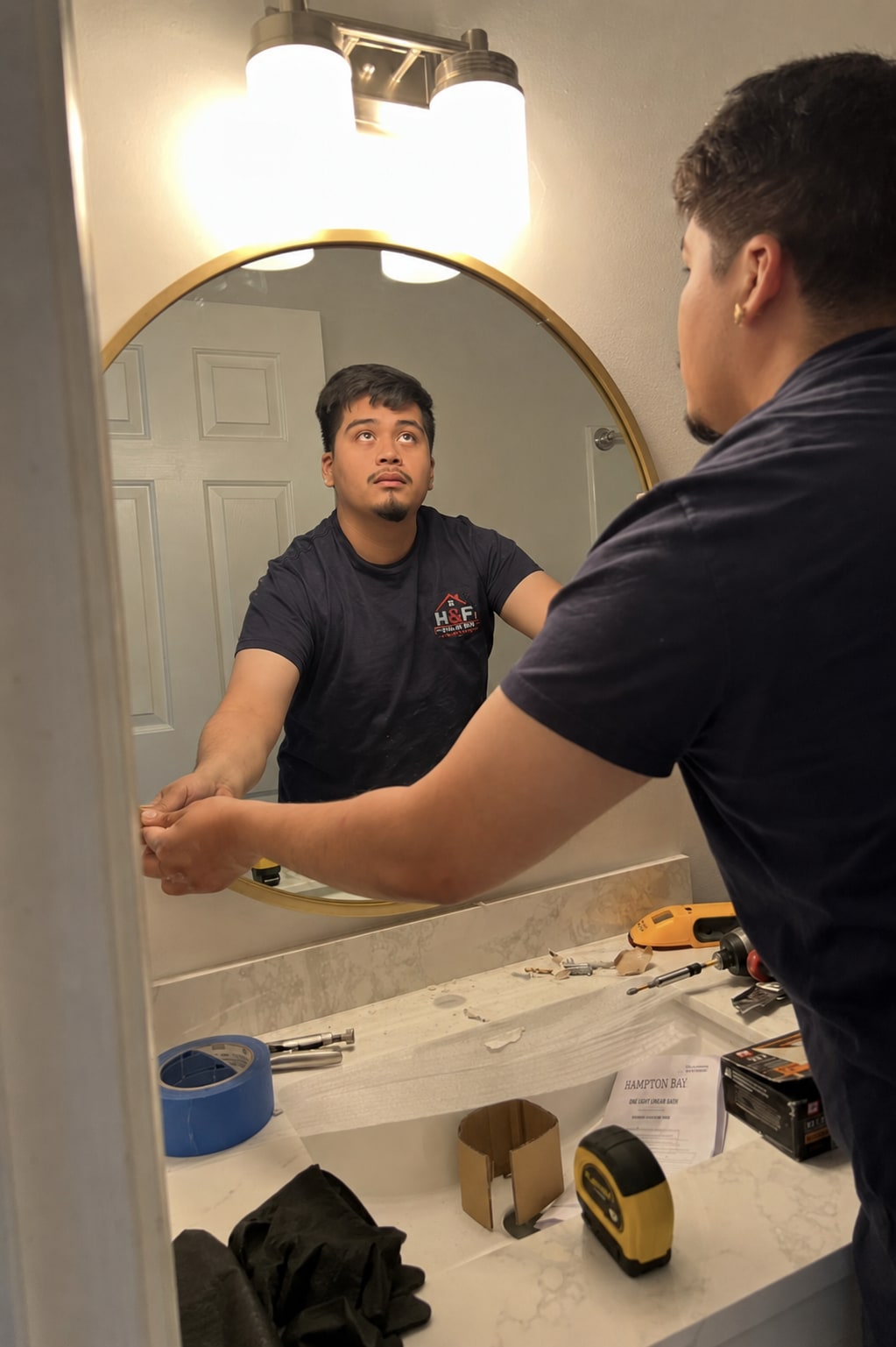 Hugo of H&F Tri-State Handyman installing a bathroom mirror